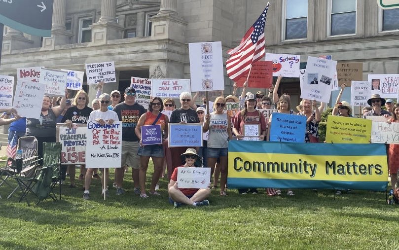 Community Matters A group with signs outside a local government building